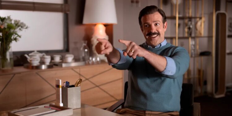 Jason Sudeikis as Ted Lasso pointing and smiling.