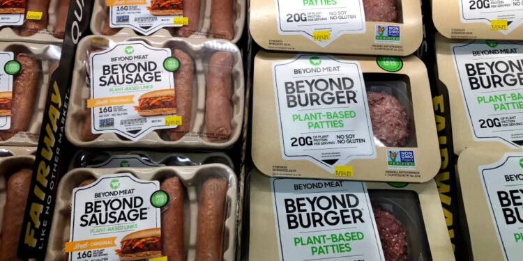 Packages of Beyond Meat's Beyond Burgers and Beyond Sausage on a shelf.