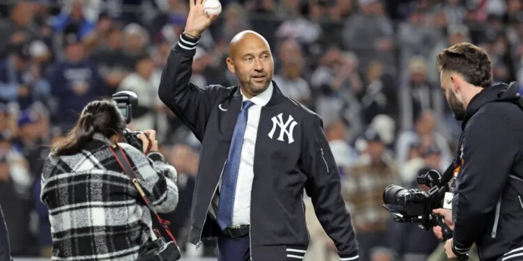 New York Yankees great Derek Jeter waves to the crowd as he walks out to throw the first pitch of the game before the start of tonightâs game.
