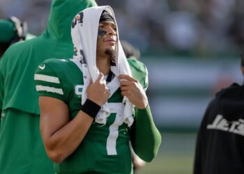Jets quarterback Justin Fields (7) watches from the sidelines during the fourth quarter of an NFL football game against the Carolina Panthers, Sunday, Oct. 19, 2025, in East Rutherford, N.J.