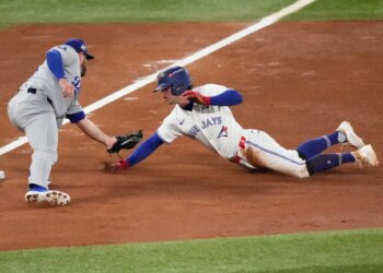 Ernie Clement of the Toronto Blue Jays is tagged out by Los Angeles Dodgers third baseman Max Muncy.