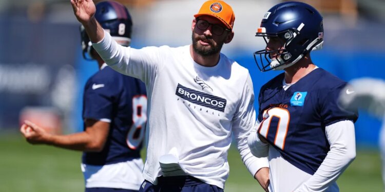 Denver Broncos quarterbacks coach Davis Webb directs quarterback Bo Nix during practice.