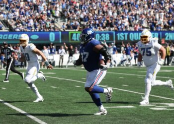New York Giants defensive tackle Dexter Lawrence II (97) returns an interception as Los Angeles Chargers quarterback Justin Herbert (10) and Los Angeles Chargers center Bradley Bozeman (75) defend during the first quarter at MetLife Stadium.