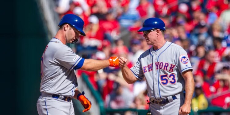 Pete Alonso and Glenn Sherlock of the New York Mets celebrate a hit with a fist bump.