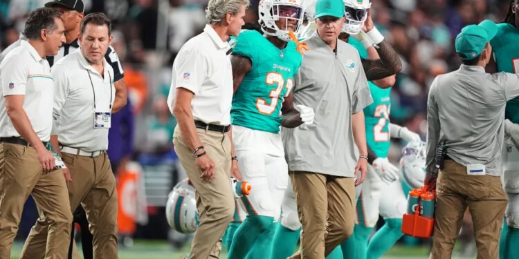 Miami Dolphins running back Ollie Gordon II (31) being helped off the field after an apparent injury.