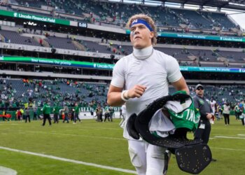 New York Giants quarterback Jaxson Dart (6) holding Saquon Barkley's jersey after the game.