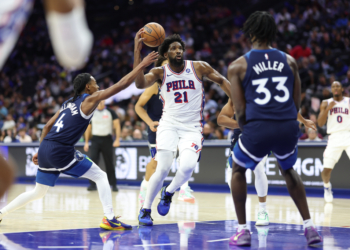 Philadelphia 76ers center Joel Embiid (21) drives between Minnesota Timberwolves guard Rob Dillingham (4) and forward Leonard Miller (33).