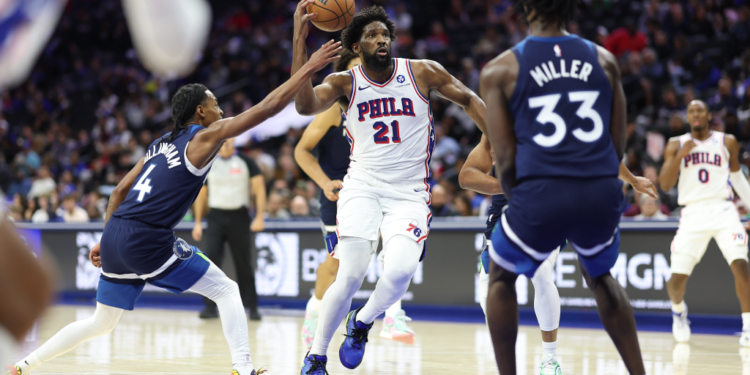 Philadelphia 76ers center Joel Embiid (21) drives between Minnesota Timberwolves guard Rob Dillingham (4) and forward Leonard Miller (33).