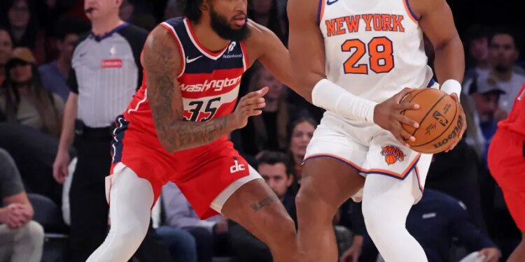 New York Knicks forward Guerschon Yabusele #28 looks for an opening as Washington Wizards Marvin Bagley III defends during the first quarter.