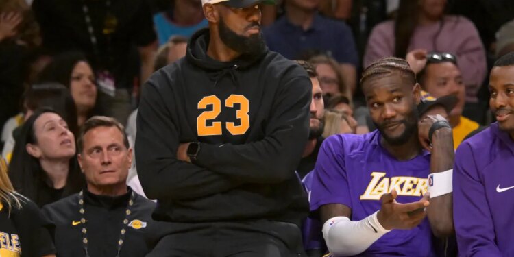 LeBron James, sitting out due to sciatica, watches the Lakers from the bench against the Warriors on Oct. 12, 2025.