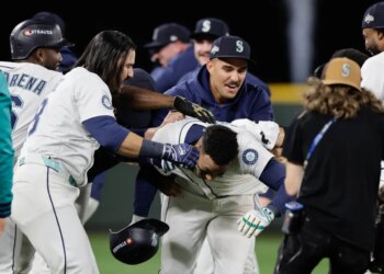 Jorge Polanco (center) is mobbed by teammates after ripping a game-winning single in the 15th inning of the Mariners' win over the Tigers in Game 5 of the ALDS on Oct. 10, 2025.