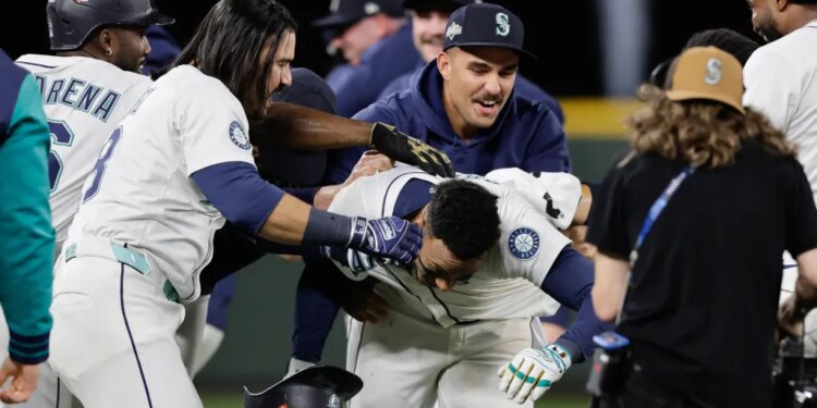 Jorge Polanco (center) is mobbed by teammates after ripping a game-winning single in the 15th inning of the Mariners' win over the Tigers in Game 5 of the ALDS on Oct. 10, 2025.