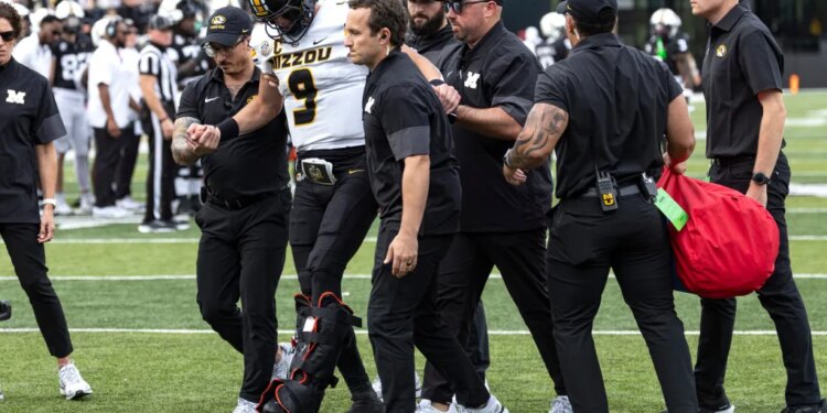 Missouri quarterback Beau Pribula (9) is assisted off the field by medical staff.