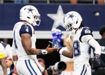 Cowboys players Dak Prescott (4) and CeeDee Lamb (88) greet each other on the field.