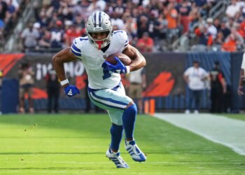 Jalen Tolbert in a white Dallas Cowboys uniform with the number 1, running with a football.