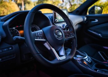 Interior of a Nissan Juke, showing the steering wheel with the Nissan logo, dashboard, and infotainment screen.