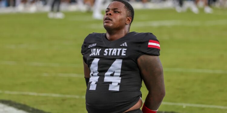 A Jacksonville State Gamecocks football player in a black jersey with the number 44 pauses on the field.