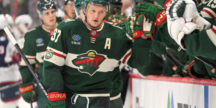 Kirill Kaprizov high-fives teammates after scoring a goal.