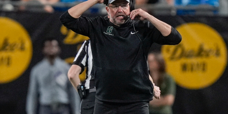 Charlotte 49ers head coach Tim Albin wearing a headset during a game.