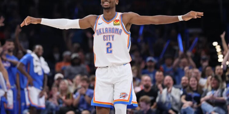 Shai Gilgeous-Alexander with his arms outstretched, smiling on the basketball court.