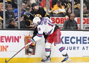 New York Rangers center Vincent Trocheck checks Boston Bruins defenseman Andrew Peeke into the boards.