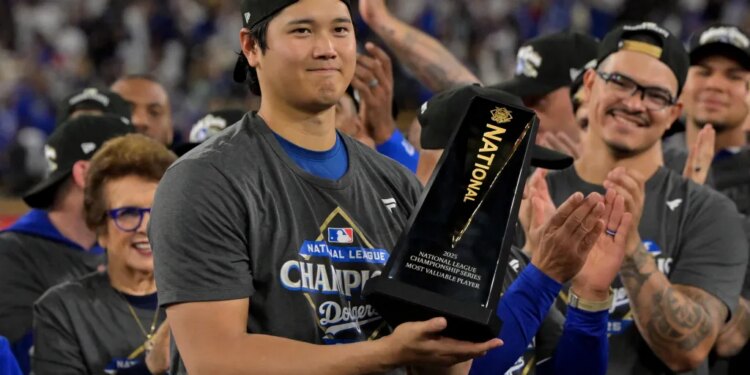 Shohei Ohtani holds the NLCS MVP trophy after the Dodgers' series-clinching Game 5 win over the Brewers.