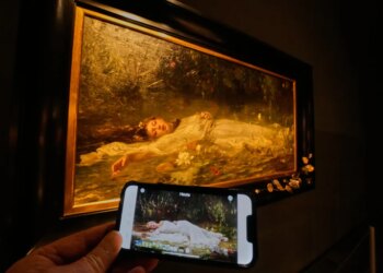Mobile phone displaying Taylor Swift's "The Fate of Ophelia" video in front of Friedrich Heyser's painting of Ophelia