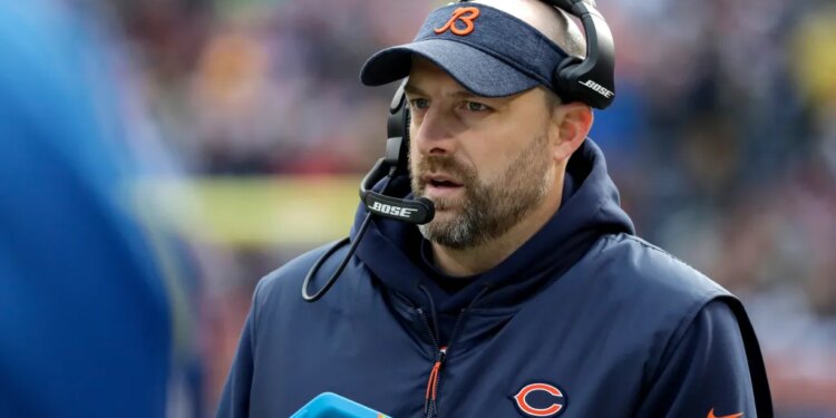 Matt Nagy wearing a Bears visor and headset while holding a Microsoft Surface tablet.