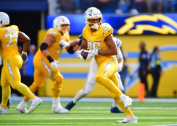 Los Angeles Chargers player in yellow uniform holding a football during a game against the Indianapolis Colts.