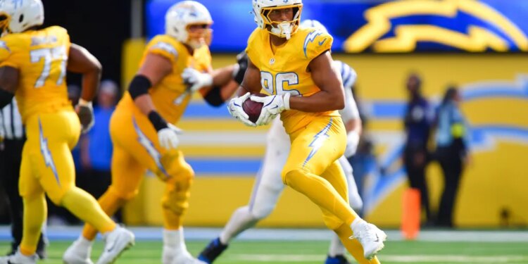 Los Angeles Chargers player in yellow uniform holding a football during a game against the Indianapolis Colts.