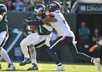 Philadelphia Eagles quarterback Jalen Hurts (1) is sacked by Denver Broncos linebacker Nik Bonitto (15).
