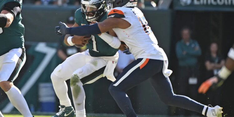 Philadelphia Eagles quarterback Jalen Hurts (1) is sacked by Denver Broncos linebacker Nik Bonitto (15).