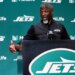 New York Jets head coach Aaron Glenn speaks at a podium.