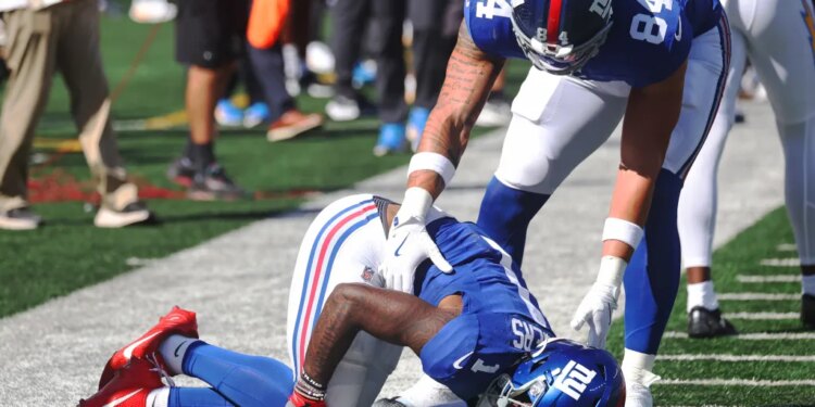 Wide receiver Malik Nabers #1 of the New York Giants jumps for a reception and falls behind cornerback Cam Hart #20 of the Los Angeles Chargers. Nabers is injured on the play during the first half when the New York Giants played the Los Angeles Chargers Sunday, September 28, 2025 at MetLife Stadium in East Rutherford, NJ.