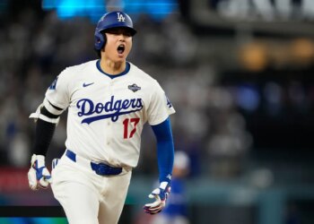 Los Angeles Dodgers player Shohei Ohtani yelling in excitement during a baseball game.