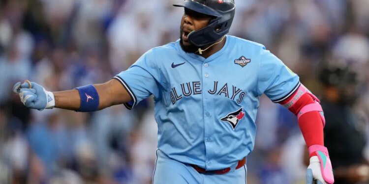 Toronto Blue Jays player in a light blue jersey, batting helmet, and a World Series patch.