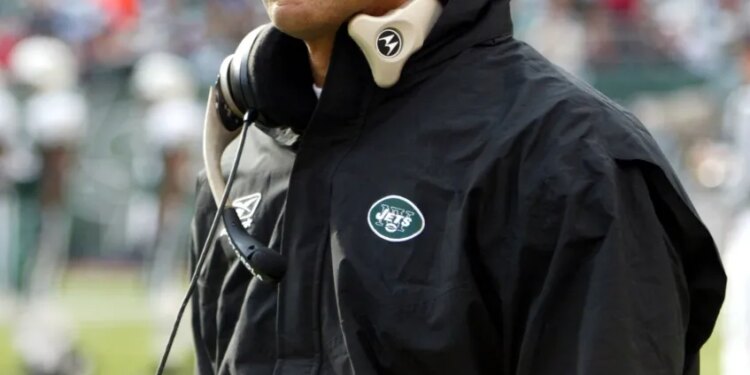 Herm Edwards, coach of the New York Jets, wearing a green cap and black jacket with a Jets logo.