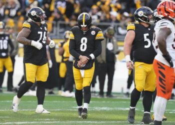 Pittsburgh Steelers quarterback Aaron Rodgers (8) holds his arm after a hit by the Cincinnati Bengals.