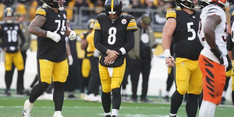Pittsburgh Steelers quarterback Aaron Rodgers (8) holds his arm after a hit by the Cincinnati Bengals.