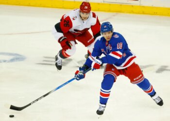 Rangers left wing Artemi Panarin (10) plays the puck against Carolina Hurricanes defenseman Sean Walker