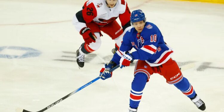 Rangers left wing Artemi Panarin (10) plays the puck against Carolina Hurricanes defenseman Sean Walker