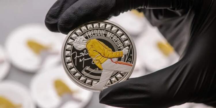 Gloved hand holding a Freddie Mercury coin.