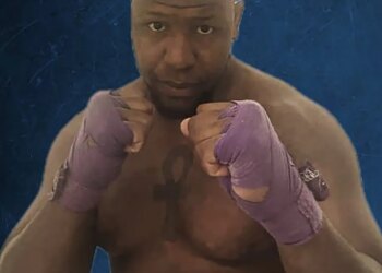 A muscular man with purple hand wraps in a fighting stance.