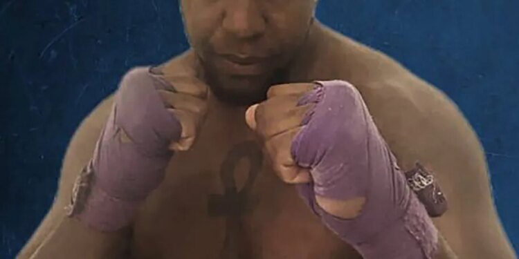 A muscular man with purple hand wraps in a fighting stance.
