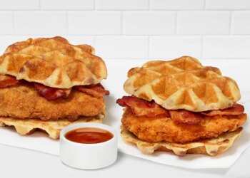 Two Chick-fil-A Waffle Breakfast Sandwiches with bacon and a side of sauce.