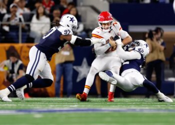 Kansas City Chiefs quarterback Patrick Mahomes is sacked by Dallas Cowboys defensive end Jadeveon Clowney, with Cowboys defensive tackle Osa Odighizuwa also watching.