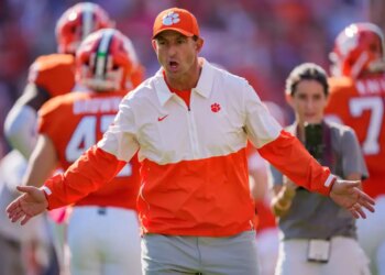 Clemson head coach Dabo Swinney greets players as they run onto the field.