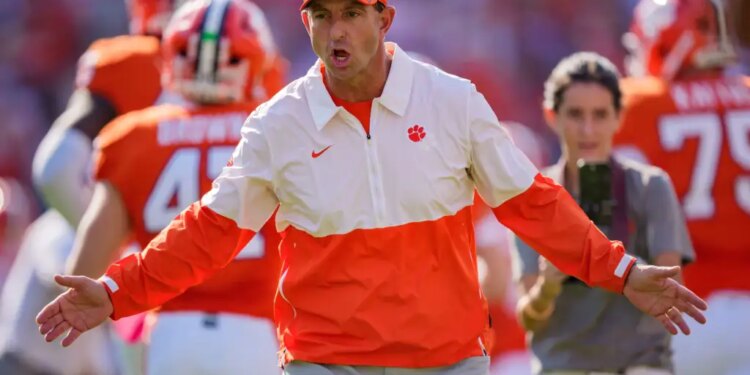 Clemson head coach Dabo Swinney greets players as they run onto the field.