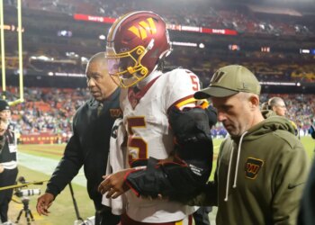 Washington Commanders quarterback Jayden Daniels (5) is helped off the field after an injury during the second half against the Seattle Seahawks.