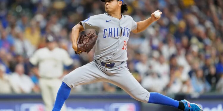 A Chicago Cubs pitcher in a grey uniform throws a baseball.